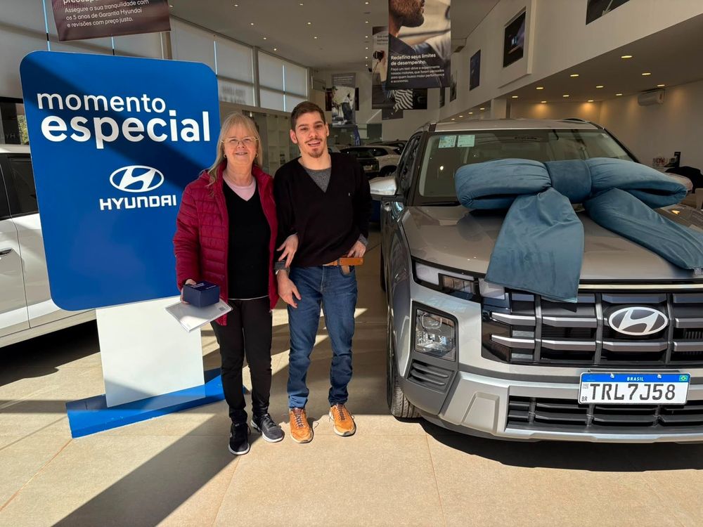 Mãe e filho ao lado do Hyundai Creta novo com laço azul